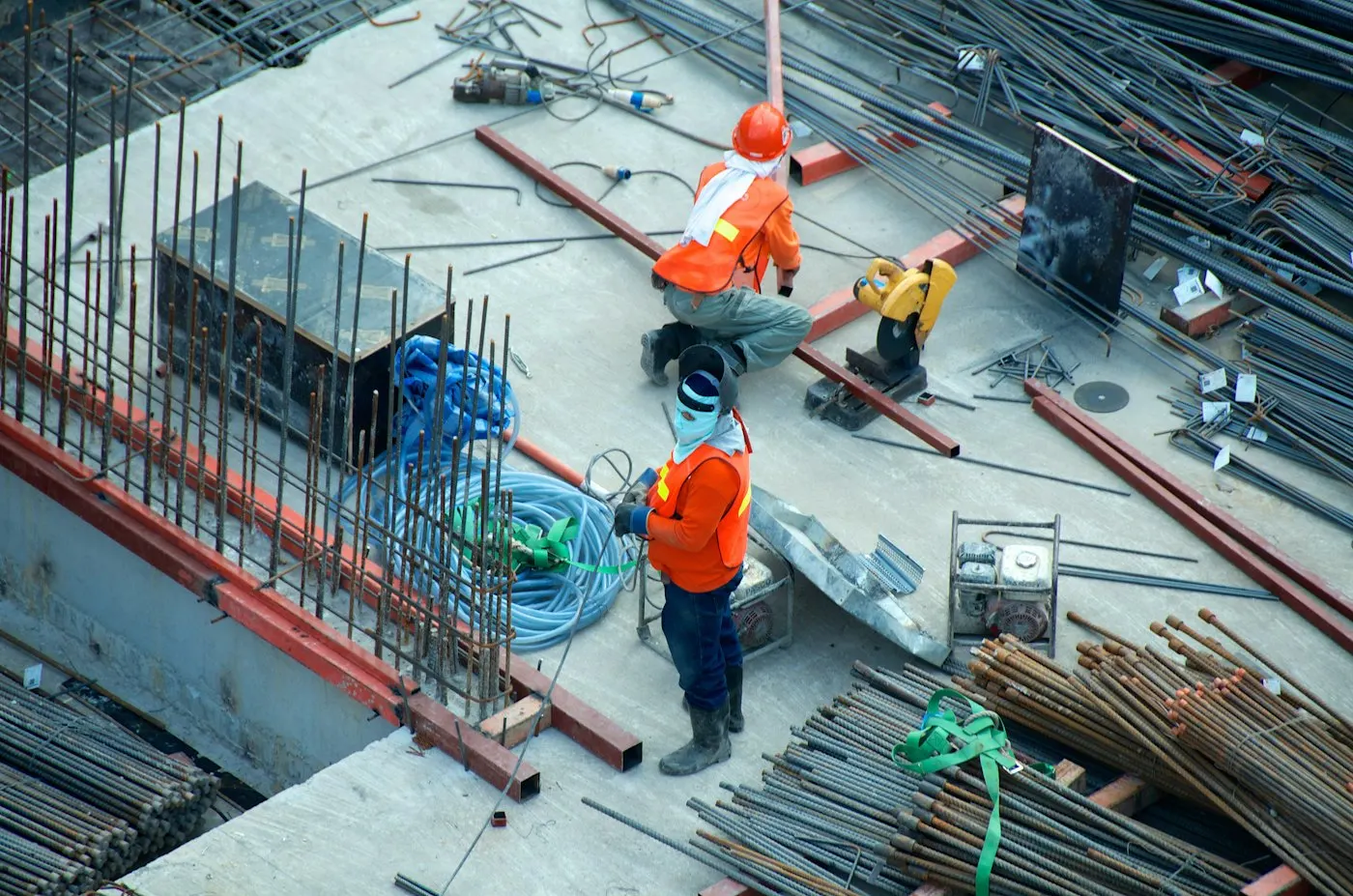 Construction workers wearing hard hats and safety vests on a building site
