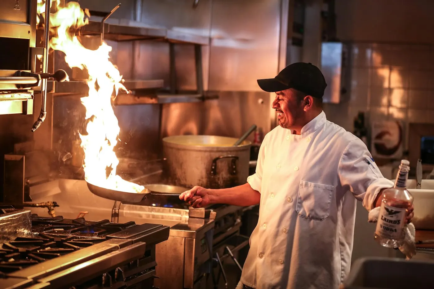 Chef cooking over a flame in a commercial kitchen